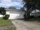 House exterior featuring a white single-car garage and well-maintained lawn at 216 Balmoral Ct, Davenport, FL 33896