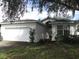One-story house with a white exterior, attached garage and manicured lawn at 216 Balmoral Ct, Davenport, FL 33896