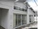 Rear exterior view showcasing large windows and sliding glass doors at 216 Balmoral Ct, Davenport, FL 33896
