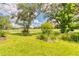 Landscaped backyard with lush greenery and a view of the golf course at 316 Treviso Dr, Poinciana, FL 34759