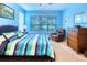 Bright bedroom featuring a large bed, window with blinds, and a relaxing chair at 316 Treviso Dr, Poinciana, FL 34759