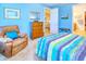 Bedroom with blue walls, a dresser, and a comfortable armchair at 316 Treviso Dr, Poinciana, FL 34759