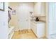 Bright laundry room with a coffee bar, coat rack, and plenty of cabinet storage at 316 Treviso Dr, Poinciana, FL 34759