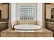 Bathroom with a free-standing oval tub and granite accents at 203 Escondido Ct, Poinciana, FL 34759