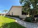 Landscaped side yard with a paved walkway at 203 Escondido Ct, Poinciana, FL 34759