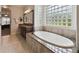 Bathroom boasting an oval soaking tub and granite vanity at 203 Escondido Ct, Poinciana, FL 34759