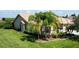Landscaped property featuring a one-story home with tile roof and palm trees at 203 Escondido Ct, Poinciana, FL 34759