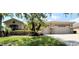 House exterior showcasing a three car garage and manicured lawn at 203 Escondido Ct, Poinciana, FL 34759