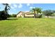 Expansive grassy yard showcasing the home's side elevation at 203 Escondido Ct, Poinciana, FL 34759