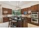Spacious kitchen with dark wood cabinets, granite island, and stainless steel appliances at 203 Escondido Ct, Poinciana, FL 34759
