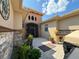 Charming courtyard entry with stonework, lush landscaping, and a paved path at 203 Escondido Ct, Poinciana, FL 34759