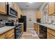 Fully equipped kitchen with modern appliances and wood cabinets at 7671 Comrow St # 202, Kissimmee, FL 34747
