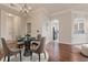 Bright dining room with a glass table and four chairs, hardwood floors, and a view of the kitchen at 501 Mirasol Cir # 424, Celebration, FL 34747