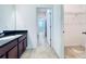 Bathroom with dark vanity, tile floor, and walk-in closet at 10091 Austrina Oak Loop, Winter Garden, FL 34787