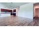 Open living room with kitchen view and wood-look floors at 10091 Austrina Oak Loop, Winter Garden, FL 34787