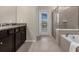 Elegant bathroom with a soaking tub, walk-in shower, and granite countertops at 3209 Lilac Way, Davenport, FL 33897
