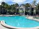 Community pool and spa with surrounding patio furniture at 3100 Parkway Blvd # 611, Kissimmee, FL 34747