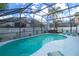 Enclosed kidney-shaped swimming pool with a spa and patio furniture at 162 Seneca Point Trl, Kissimmee, FL 34746