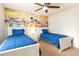 Twin bedroom with Disney mural and two twin beds at 9047 Rhodes St, Kissimmee, FL 34747
