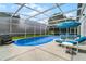 Screened pool area with lounge chairs and hot tub at 7959 Magnolia Bend Ct, Kissimmee, FL 34747