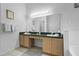 Double vanity bathroom with wood cabinets and a large mirror at 7959 Magnolia Bend Ct, Kissimmee, FL 34747
