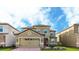Two-story house with a three car garage and well-manicured lawn at 1495 Rolling Fairways Dr, Davenport, FL 33896