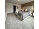 Bright main bedroom with a king-size bed, plush carpet, and an ensuite bathroom at 718 Longboat Dr, Davenport, FL 33896