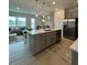 Open kitchen features an island, stainless steel appliances, and a view into the living room at 718 Longboat Dr, Davenport, FL 33896
