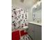 Bathroom with Mickey Mouse shower curtain, gray vanity, and red accents at 718 Longboat Dr, Davenport, FL 33896