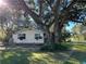 Front view of a house showcasing a large tree at 6790 Bass Hwy, St Cloud, FL 34771