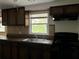 Bright kitchen features wood cabinets, a double sink, and a stove at 6790 Bass Hwy, Saint Cloud, FL 34771