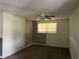 Living room with grey accent wall, ceiling fan and carpeted floor at 6790 Bass Hwy, St Cloud, FL 34771