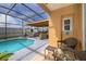 Inviting screened pool area with patio furniture and lush landscaping at 905 Knollwood Dr, Davenport, FL 33837