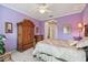 Primary bedroom with lavender walls, wooden furniture, and large windows at 227 Verona Dr, Poinciana, FL 34759
