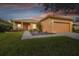 Single-story house with landscaped yard, paved walkway, and two-car garage at 227 Verona Dr, Poinciana, FL 34759