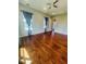 Large bedroom with hardwood floors, dual windows, and blue curtains at 1980 Poblado Ct, Kissimmee, FL 34744