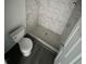 Bathroom with a shower, toilet and marble-tiled walls at 1339 Tallahassee Ct, Kissimmee, FL 34759