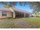Back exterior of house featuring a screened porch and grassy yard at 2771 Cedaridge Cir, Clermont, FL 34711