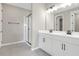 Modern bathroom with double vanity, shower, and gray tile flooring at 4216 Sawtooth Ct, Tavares, FL 32778