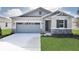 New construction home with gray siding, stone accents, and a two-car garage at 4216 Sawtooth Ct, Tavares, FL 32778