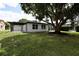Landscaped backyard with large tree and renovated home at 10633 Watertown Ct, Orlando, FL 32821