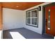 Inviting front porch with an orange door and wood ceiling at 10633 Watertown Ct, Orlando, FL 32821