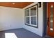 Inviting front porch with an orange door and wood ceiling at 10633 Watertown Ct, Orlando, FL 32821