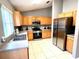 Open kitchen with stainless steel appliances and wood cabinets at 2556 Bear Creek Ct, Kissimmee, FL 34747