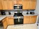 Kitchen with gas range, microwave, and wood cabinets at 2556 Bear Creek Ct, Kissimmee, FL 34747