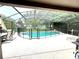Relaxing screened pool area with waterfall feature and lounge chairs at 2556 Bear Creek Ct, Kissimmee, FL 34747