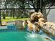 Close up of a rock waterfall feature in the screened pool area at 2556 Bear Creek Ct, Kissimmee, FL 34747