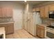 Kitchen with white appliances, light wood cabinets, and tile floor at 4311 Sw 53Rd Ter, Ocala, FL 34474