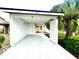 A carport with a light-colored concrete floor and a yellow house in the background at 457 Prestwick Pl # 457, Kissimmee, FL 34759