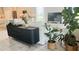 Open living room with white couch, black cabinet, and large plants at 13706 Werrington Dr, Winter Garden, FL 34787
